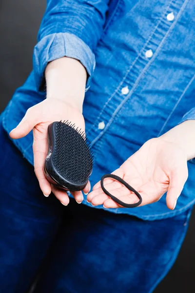 Mani femminili con pettine e capelli elastici . — Foto Stock