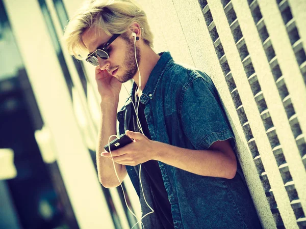 Hipster homem ouvindo música através de fones de ouvido — Fotografia de Stock