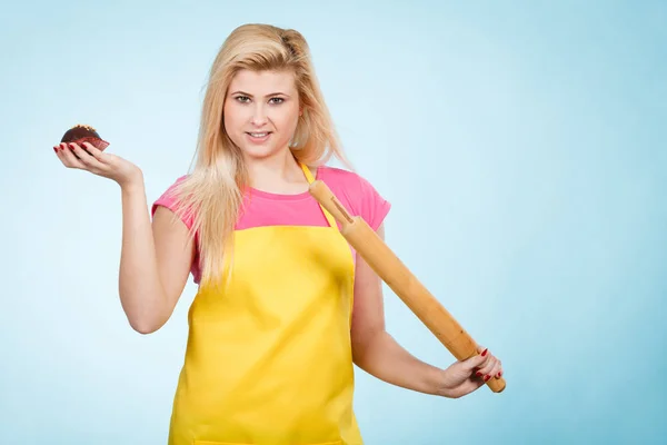 Mulher segurando cupcake e rolo pin vestindo avental — Fotografia de Stock