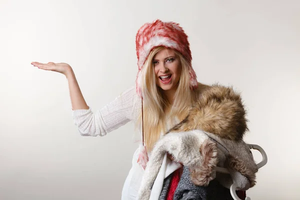 Γυναίκα με καπέλο χειμώνα κρατά το σωρό των ρούχων — Φωτογραφία Αρχείου