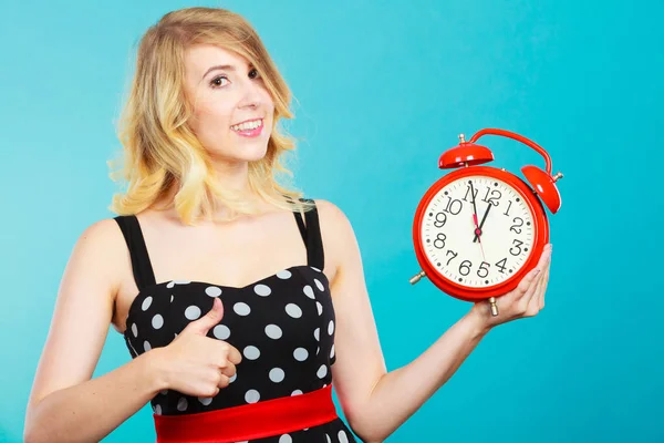 Lachende meisje met wekker op blauw. — Stockfoto