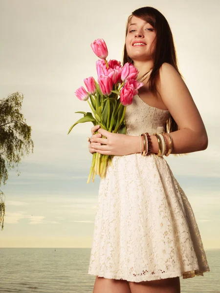 Retrato de mujer sosteniendo flores en la playa —  Fotos de Stock