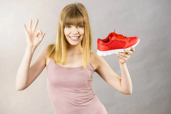 Gelukkige vrouw presenteren sportkleding trainers schoenen — Stockfoto