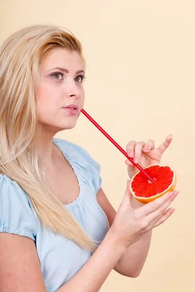 Woman drinking juice from fruit, red grapefruit — Stock Photo, Image