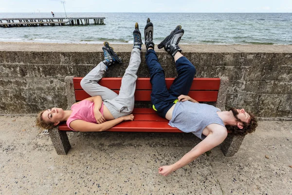 Młody zmęczony osób znajomych relaksujący na ławce. — Zdjęcie stockowe