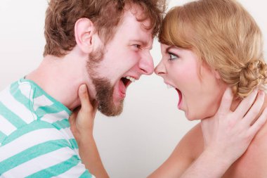 Öfkeli kadın ve erkek birbirlerine bağırıyorlar.