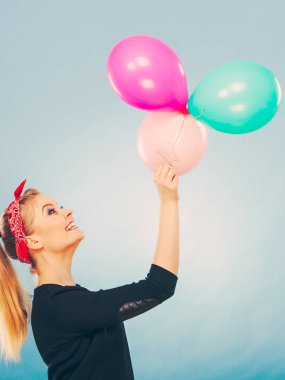 Balonlarla eğleniyor gülümseyen çılgın kız.