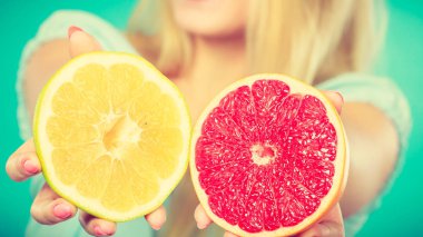 Kırmızı ve yeşil greyfurt tutan kadın