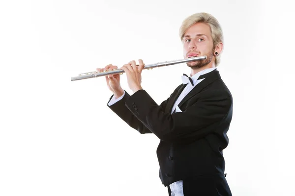 Male flutist wearing tailcoat plays flute — Stock Photo, Image