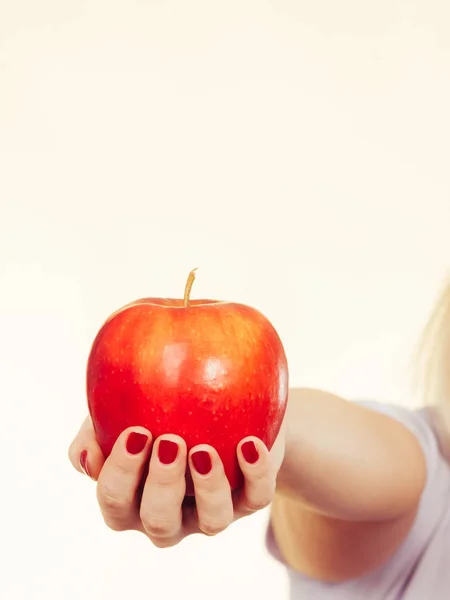 Woman hand holding delicious red apple — Stock Photo, Image