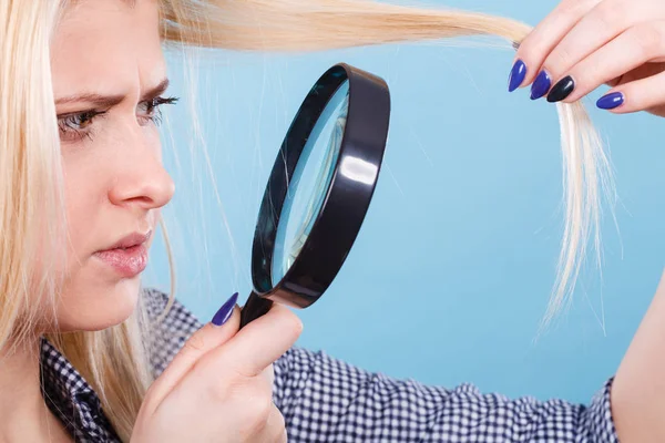 Femme regardant les cheveux à travers la loupe — Photo