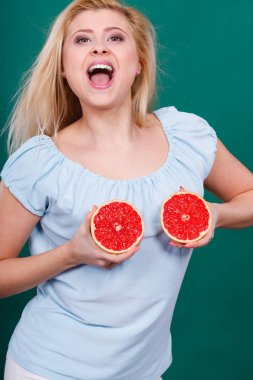 Kadın greyfurt narenciye meyve meme üzerinde tutar