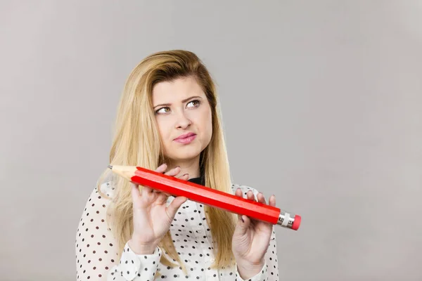 Woman confused thinking, big pencil in hand — Stock Photo, Image