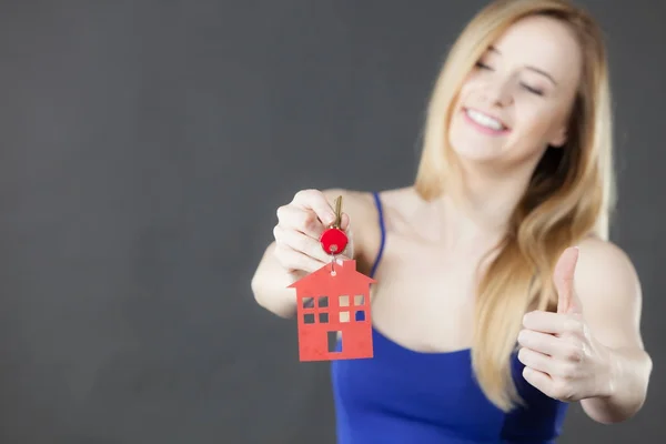 Woman holding key with house symbol — Stock Photo, Image