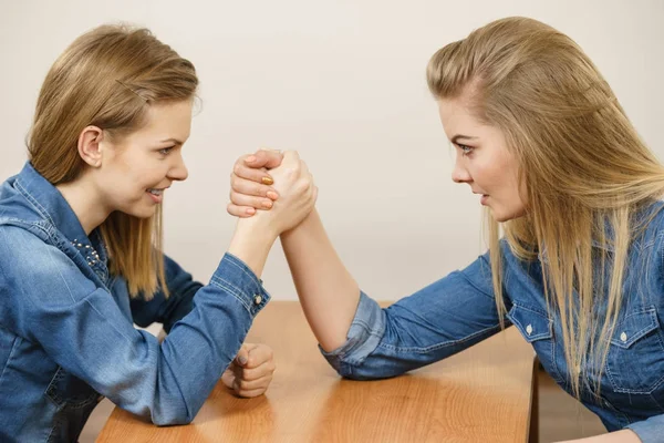 Two women having arm wrestling fight