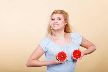 Kırmızı greyfurt meme üzerinde tutan kadın