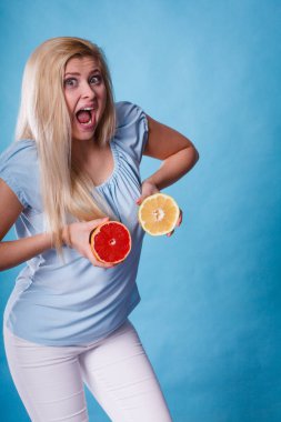 Kırmızı ve yeşil greyfurt tutan kadın