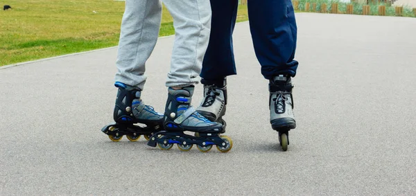 Due persone pattinaggio all'aperto, solo gambe — Foto Stock