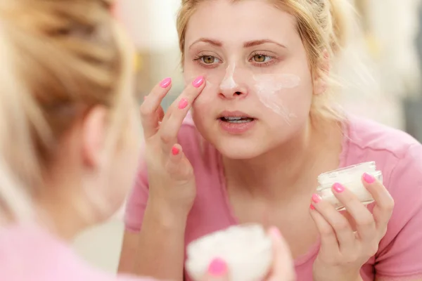 Mujer aplicando crema facial con el dedo — Foto de Stock