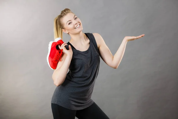 Счастливая женщина представляет спортивные кроссовки — стоковое фото