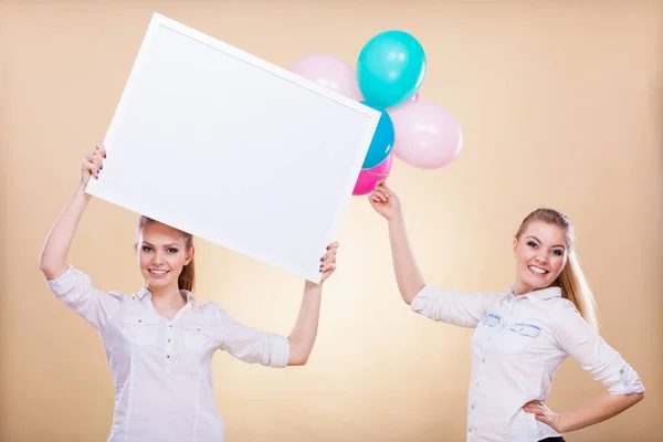 Two girls with blank board and balloons — Stock Photo, Image
