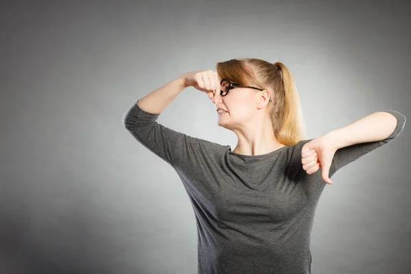 Nerdy girl holding nose. — Stock Photo, Image