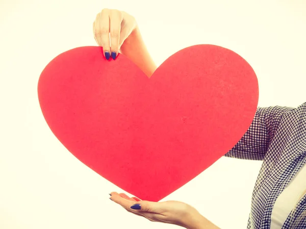 Женщина держит большое красное сердце, знак любви — стоковое фото