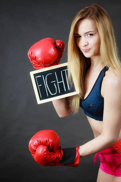 Femme portant un gant de boxe tenant un signe de combat — Photo