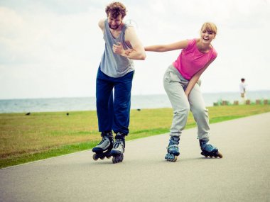Genç bir çift paten yaparken elele