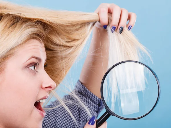 Γυναίκα κοιτάζοντας τα μαλλιά μέσα από μεγεθυντικό φακό — Φωτογραφία Αρχείου