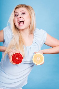 Kırmızı ve yeşil greyfurt tutan kadın