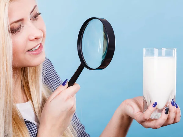 Vrouw op zoek naar melk door vergrootglas — Stockfoto