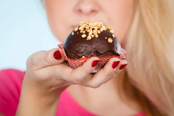 Donna che tiene un cupcake al cioccolato in procinto di mordere — Foto Stock