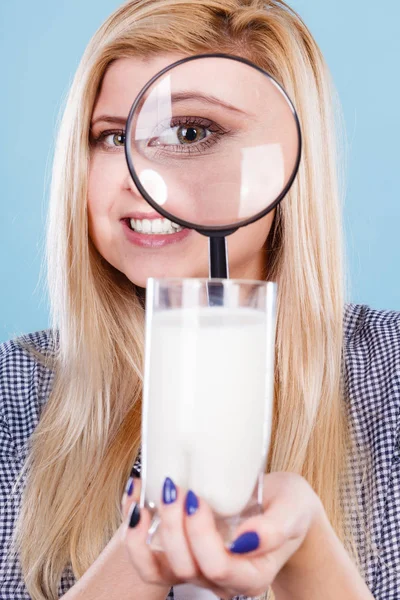 Vrouw op zoek naar melk door vergrootglas — Stockfoto