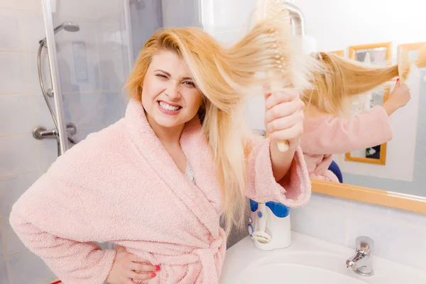 Kobieta ubrana szlafrok szczotkowanie jej włosy — Zdjęcie stockowe