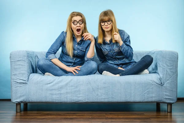 Two shocked women holding fake eyeglasses on stick — Stock Photo, Image
