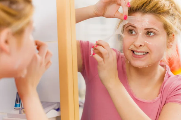 Woman peeling off gel mask from face — Stock Photo, Image