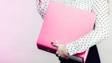Belgelerle pembe cilt tutan kadın