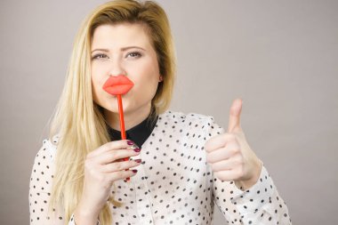 Sahte dudaklar sopa üzerinde tutan mutlu kadın