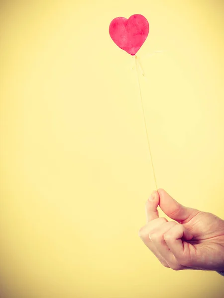 Mannenhand met kleine hart op stok. — Stockfoto