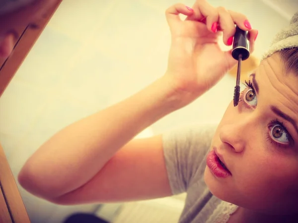 Vrouw in badkamer toepassing van mascara op wimpers — Stockfoto