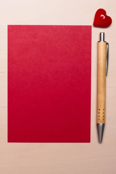 Folha em branco de papel coração e caneta na mesa — Fotografia de Stock