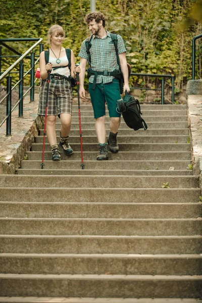 Two people tourists hiking walking on stairs.