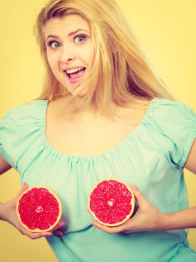 Kırmızı greyfurt meme üzerinde tutan kadın
