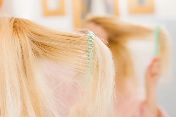 Жінка в сукні чистить волосся — стокове фото