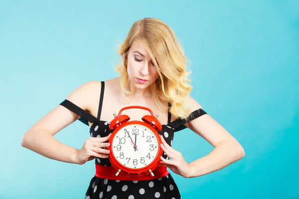 Serious girl with alarm clock on blue. — Stock Photo, Image