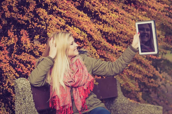 Vrouw ontspannen zittend op bankje in park met behulp van Tablet PC — Stockfoto