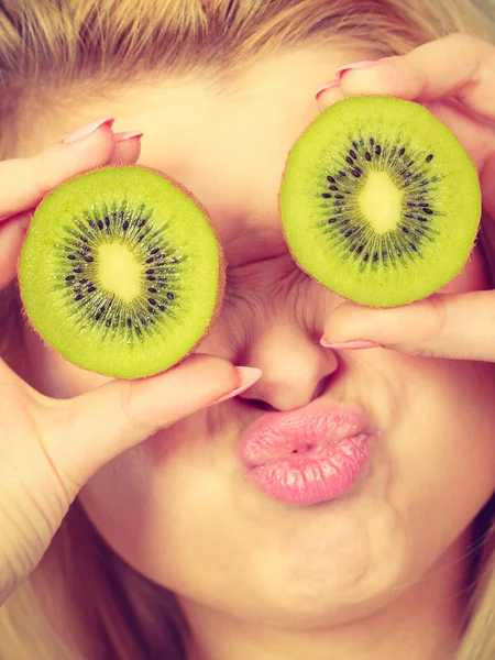 Vrouw met groene kiwi fruit zoals brillen — Stockfoto