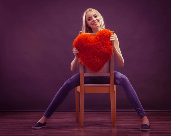 Mujer sosteniendo corazón en forma de almohada símbolo de amor — Foto de Stock