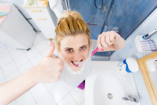 Kvinnan borsta rengöring tänder i badrum — Stockfoto
